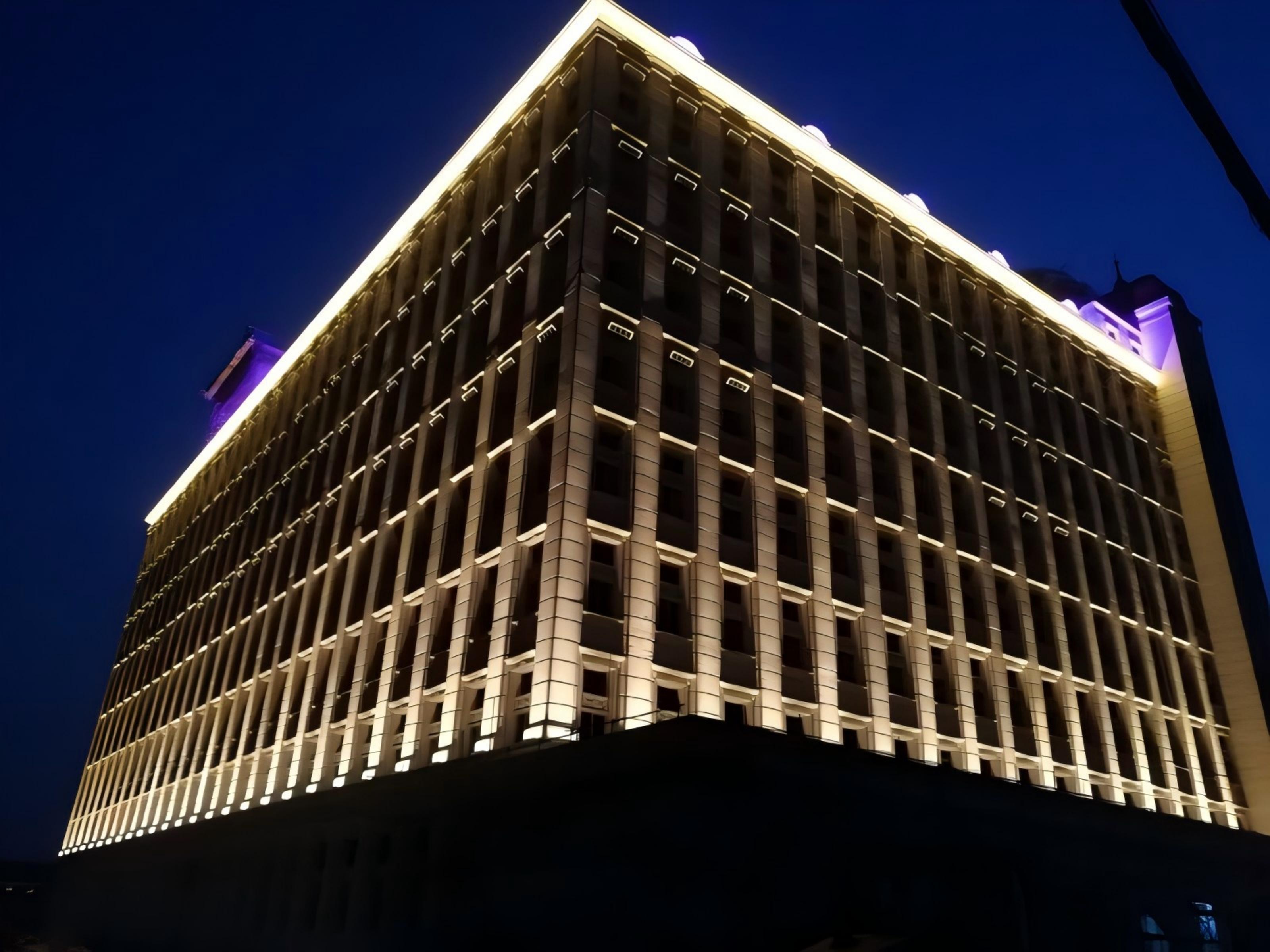 Architectural facade lighting using wall washer fixtures to create even illumination across the building exterior.