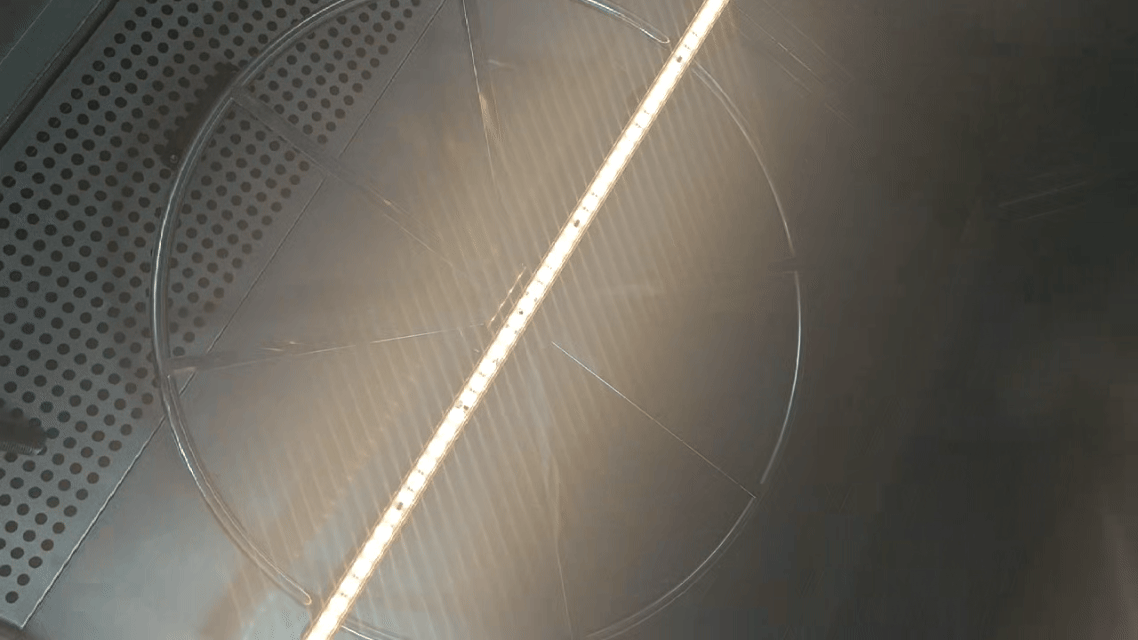 Close-up view of a linear LED wall washer showing optical diffuser structure and uniform light distribution for architectural facade lighting